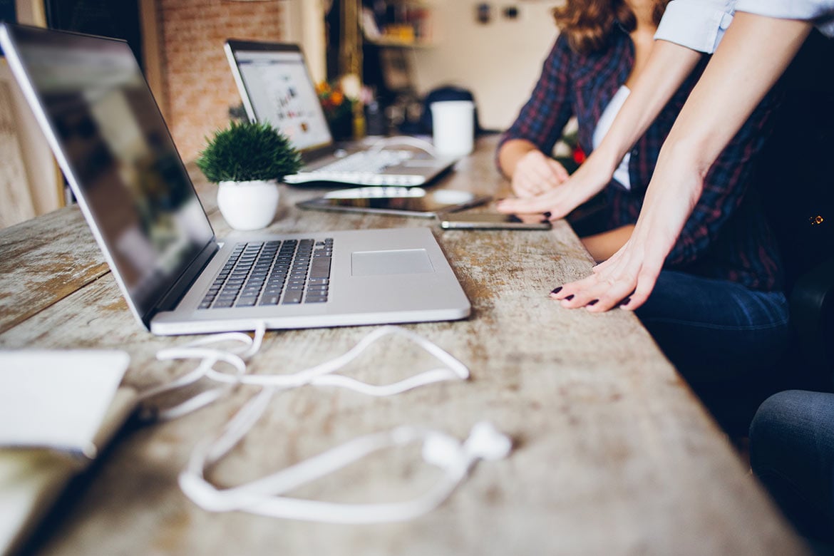 two person on table with laptop