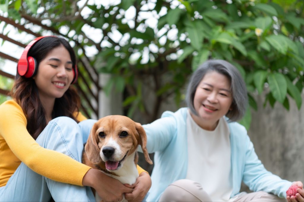 two girl holding and caressing a dog